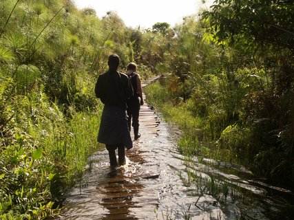 Zwei Menschen wandern durch ein Flussbett in Uganda