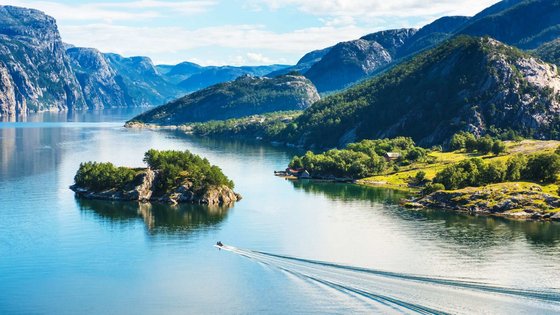 Der Vordergrund wird durch Wasser ausgefüllt, im Hintergrund liegen Berge.