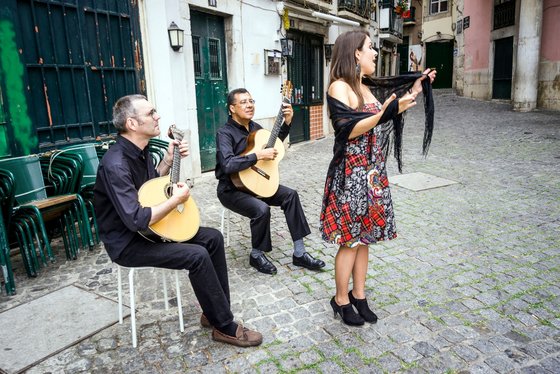 Eine Fado-Band spielt in den Gassen von Lissabon Eine Sängerin und zwei Gitarristen spielen auf der Straße