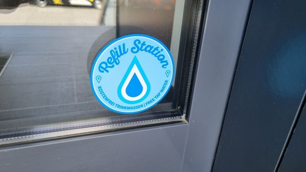 Ein Sticker an einer Glastür, auf dem "Refill-Station" steht