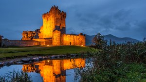 Eine Burg in Irland Eine beleuchtete Burg am Abend in Irland an einem Fluss