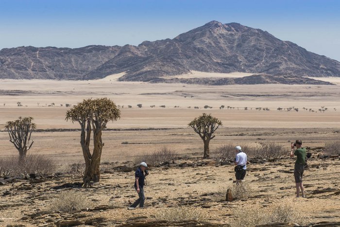 Reisegruppe blickt in die Wüste 