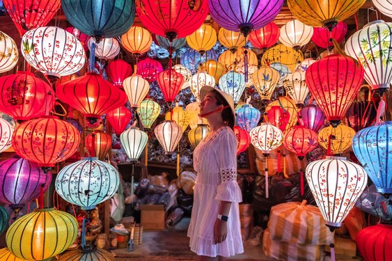 Eine Frau steht in einem Geschäft mit bunten Laternen in Hoi an