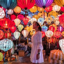 Eine Frau steht in einem Geschäft mit bunten Laternen in Hoi an