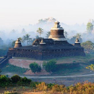 Tempel im Nebeldunst umgeben von Bäumen