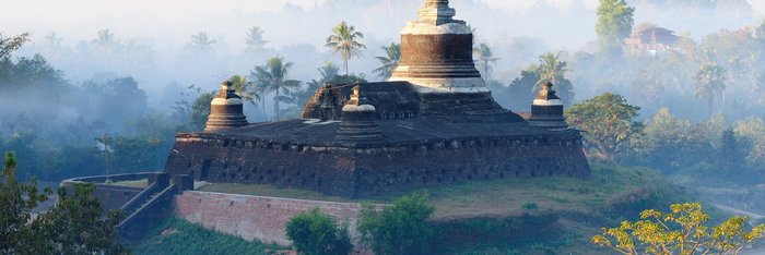 Tempel im Nebeldunst umgeben von Bäumen