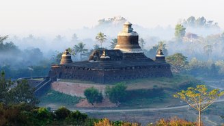 Tempel im Nebeldunst umgeben von Bäumen
