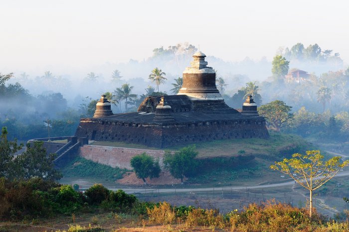 Tempel im Nebeldunst umgeben von Bäumen