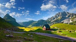 Blick auf ein Tal mit Hütte vor den Durmitor Bergen unter klarem, blauen Himmel in Montenegro.