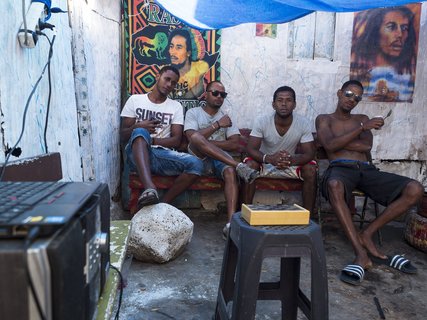 Einheimische Männer der Kapverden sitzen in einem Raum mit Postern an der Wand