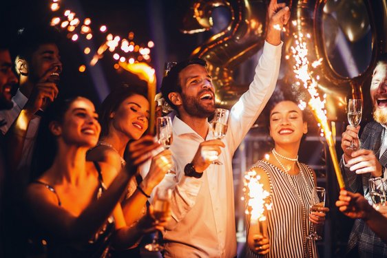 Freunde feiern Silvester mit Sekt und Wunderkerzen