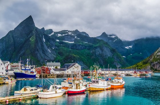 Reine am Reinefjord auf den Lofoten in Norwegen viele kleine Boote am Anlagesteg im Dorf