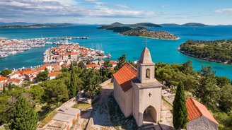 Historische Nikolauskirche in Tribunj, Kroatien, auf einem Hügel mit Blick auf das Meer. Die kleine Steinkirche besticht durch ihre schlichte Architektur und ihre markante Lage über der Küstenlandschaft.