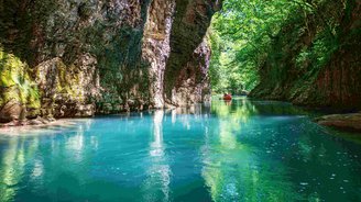 Mit Wasser gefüllte Schlucht, auf dem ein Kanu fährt