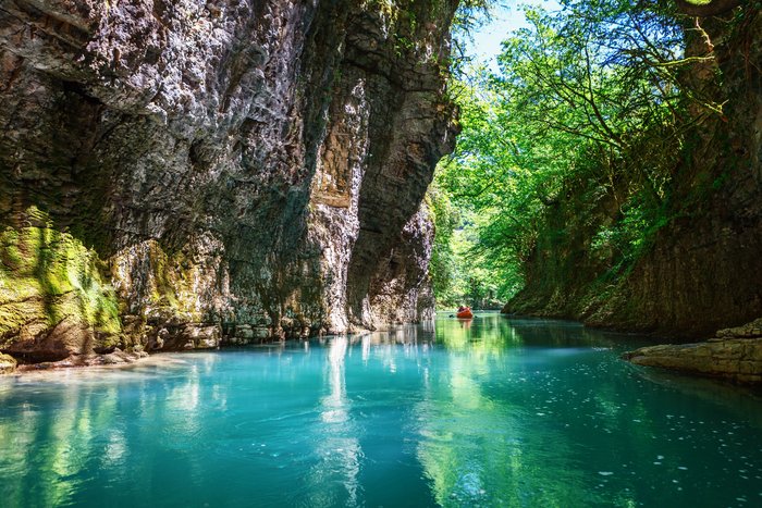 Mit Wasser gefüllte Schlucht, auf dem ein Kanu fährt