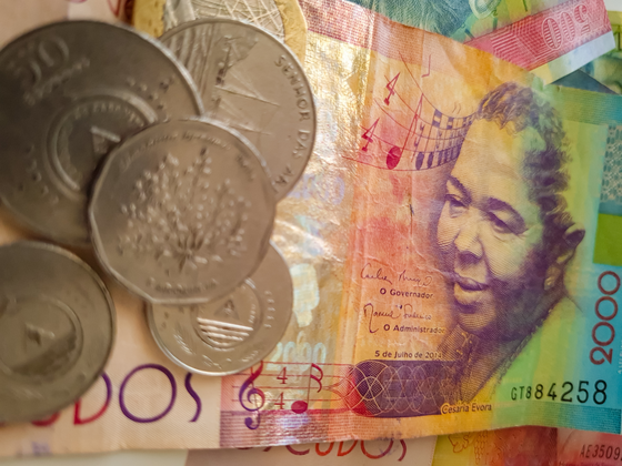 Ein 2.000-Escudos-Schein mit dem Bildnis Cesaria Evoras Man sieht einen Geldschein von Cabo Verde mit dem Bildnis Cesaria Evoras rechts, links liegen noch Geldmünzen auf dem Schein.