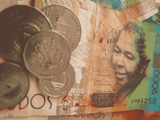 Man sieht einen Geldschein von Cabo Verde mit dem Bildnis Cesaria Evoras rechts, links liegen noch Geldmünzen auf dem Schein.