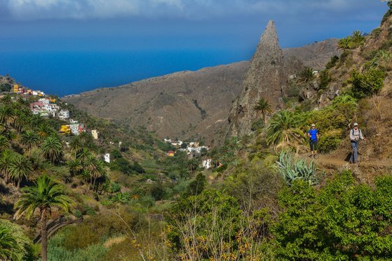Wanderer auf einem Wanderweg auf den Bergen von La Gomera, im Hintergrund das Meer.