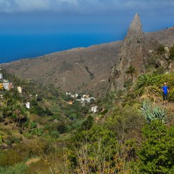Wanderer auf einem Wanderweg auf den Bergen von La Gomera, im Hintergrund das Meer.