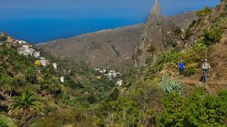 Wanderer auf einem Wanderweg auf den Bergen von La Gomera, im Hintergrund das Meer.