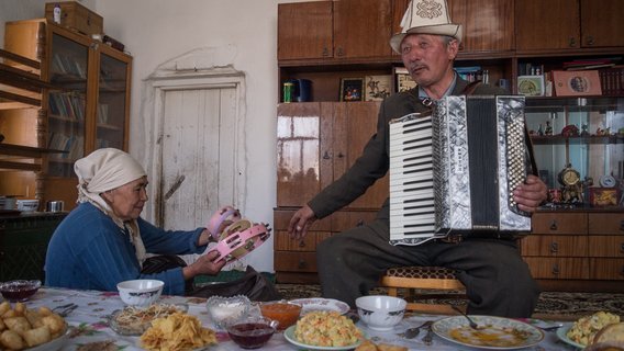 Ein Mann und eine Frau spielen im Wohnzimmer auf Instrumenten