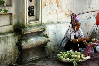 Alltag in Hanoi, Vietnam Frau verkauft frisches Obst am Straßenrand in Hanoi.