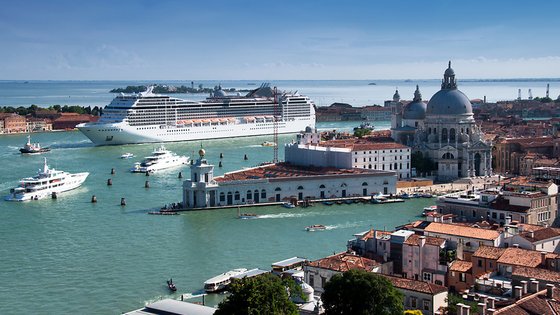 Bucht von Venedig mit grünlich, blauem Wasser. Große Kreuzfahrtschiffe kehren in die Bucht ein.