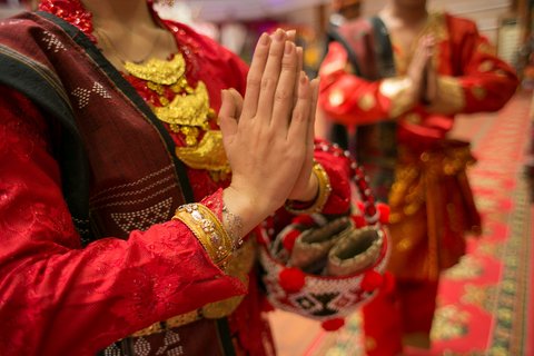 Nahaufnahme von gefalteten Händen zweier tanzender Frauen in traditioneller Kleidung