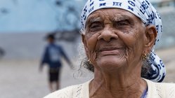 Portät einer älteren, einheimischen Frau mit einem blau-weißen Kopftuch