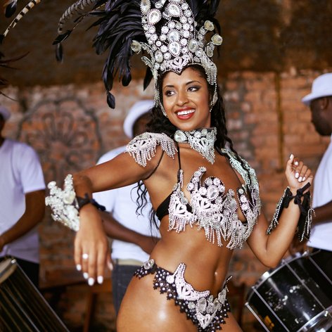 Eine verkleidete Frau tanzt Samba beim Karneval