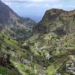 Blick von oben auf ein grünes Tal.