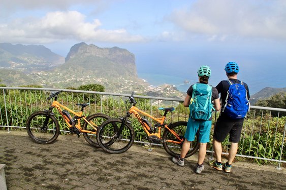 Zwei Radfahrer blicken auf die Küste von Madeira