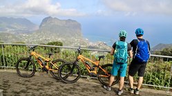 Zwei Radfahrer blicken auf die Küste von Madeira