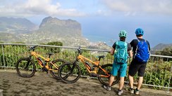 Zwei Radfahrer blicken auf die Küste von Madeira