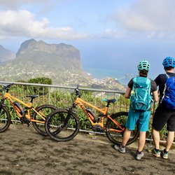 Zwei Radfahrer blicken auf die Küste von Madeira