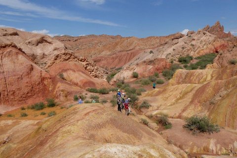 Eine Reisegruppe erkundet die Landschaft aus Sandgestein