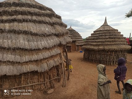 Kinder des Karamojong-Volks zwischen Hütten