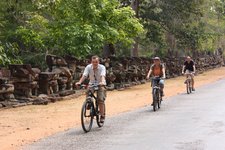Touristen fahren mit dem Fahrrad durch Angkor Thom