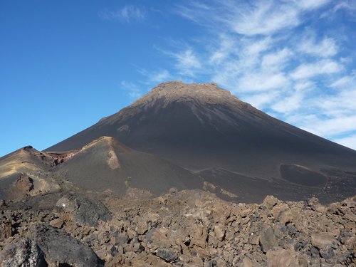Blick auf den Vulkan Pico de Fogo mit blauem, leicht bewölktem Himmel im Hintergrund.