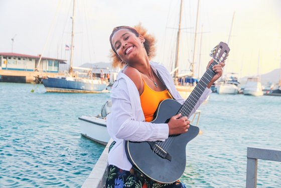 Claudia Sofia e Banda Frau spielt Gitarre am Wasser.