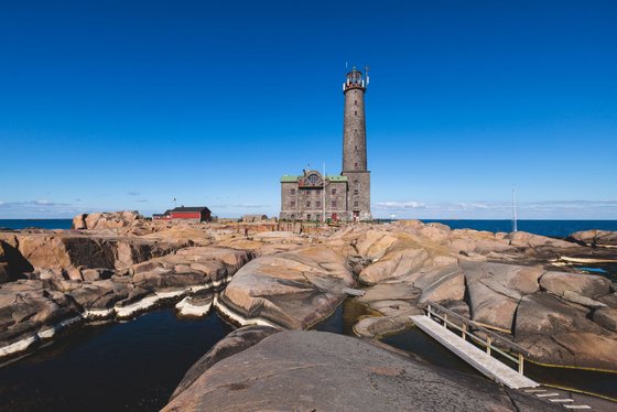 Der Leuchtturm Bengstkär in Finnland Ein Leuchtturm steht auf einer felsigen Schärenlandschaft in Finnland