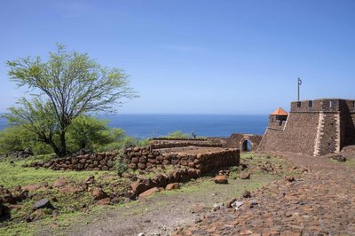 Das UNESCO-Welterbe Cidade Velha gehört zu den Sehenswürdigkeiten der Kapverden. Auf dem Foto ist die alte Festungsanlage zu sehen, dahinter erstreckt sich blauer Ozean.