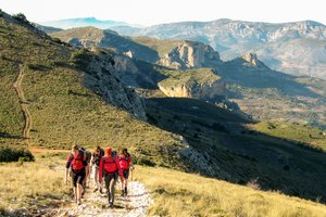 Wandergruppe wandert durch das Aitana Gebirge mit Blick auf die Berge im Hintergrund