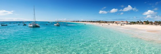 Herrliche Strände auf Sal Im Vordergrund erstreckt sich der kristallklare, türkise Atlantik, im Hintergrund sieht man einen schönen Sandstrand.