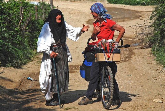 Angeregte Unterhaltung zwischen einer Frau mit Gehstock und einer Frau auf dem Fahrrad