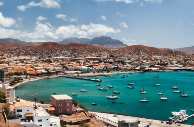 Längs einer Bucht mit türkisblauem Wasser, auf dem Segelboote dümpeln, erstreckt sich der Hauptort São Vicentes Mindelo.
