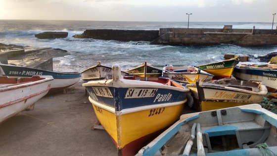 Fischerboote am Strand von Ponta do Sol auf Santo Antão Bunte Fischerboote liegen am Strand vor einer rauen See.