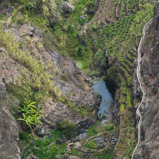 Blci von oben auf ein Tal mit einem Fluss und grünen Pflanzen auf den Kapverden