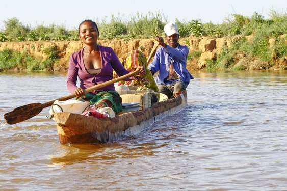 Herzliche Einheimische paddeln auf einem Fluss in Madagaskar
