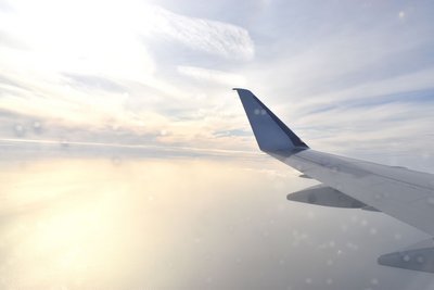 Ein Flugzeugflügel vor Wolken